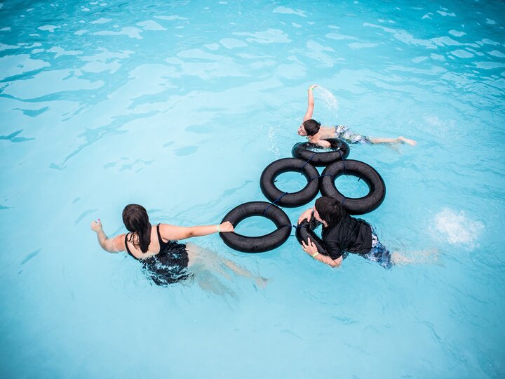 Youth campers swimming with intertubes